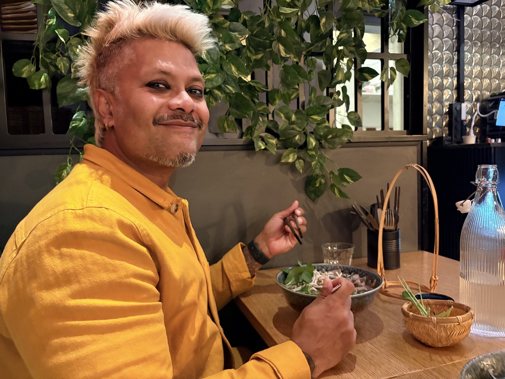 Rahul enjoying ramen at a restaurant.